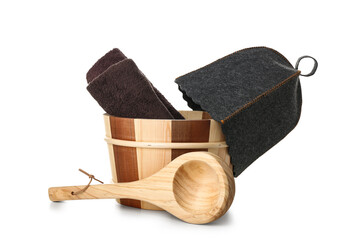 Wooden bucket with towels, felt hat and ladle for sauna on white background