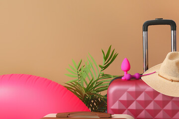 Suitcase, sex toys and beach accessories on color background, closeup