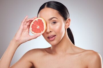 Beauty, grapefruit and portrait with natural woman closeup in studio on gray background for wellness. Aesthetic, fruit and skincare with aesthetic model at spa for cosmetics or dermatology treatment