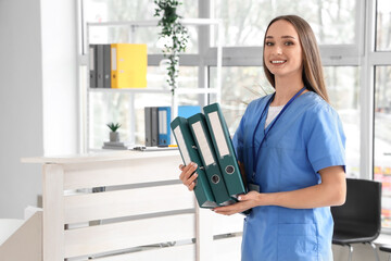Female receptionist with folders in clinic