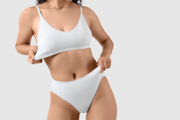 Young woman in underwear on light background, closeup