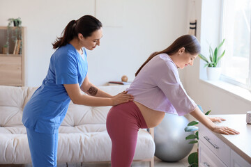 Young pregnant woman with doula at home