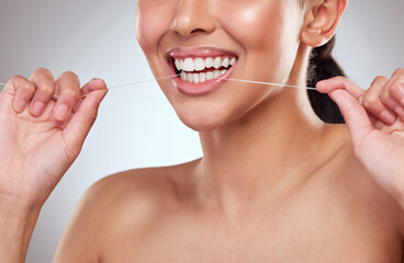 Dental floss, smile or teeth of person closeup in studio on gray background for cleaning and oral hygiene. Dentist, hands and mouth with product for tooth care to prevent cavity, decay or gum disease