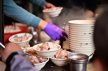Taiwan - Feb 01, 2024: A glimpse into the culinary artistry of a food stall preparing tender braised pork knuckles, a Taiwan - Feb 01, 2024: A glimpse into the cudelicacy renowned for its rich flavor.