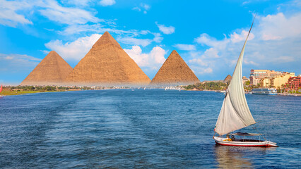 Beautiful Nile scenery with traditional Felluca sailing boat in the Nile on the way to Giza pyramids - Cairo, Egypt