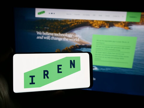 Stuttgart, Germany - 05-02-2024: Person holding mobile phone with logo of Australian Bitcoin mining company Iris Energy Ltd. (IREN) in front of web page. Focus on phone display.