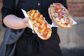 Woman holding sandwich called Zapiekanka near the Okrąglak street food court on Plac Nowy, Jewish...