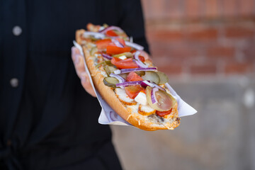 Woman holding sandwich called Zapiekanka near the Okrąglak street food court on Plac Nowy, Jewish...