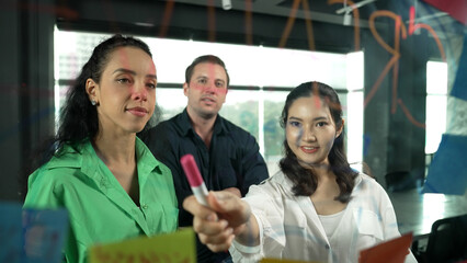 Portrait of professional diverse business team brainstorming marketing idea on colorful sticky...