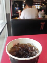 Cola drink with ice cubes on table