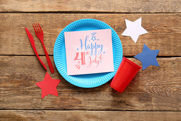 Composition with dinnerware, greeting card for Independence Day celebration and paper stars on...