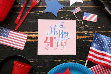 Composition with greeting card for Independence Day celebration, dinnerware and USA flags on dark...