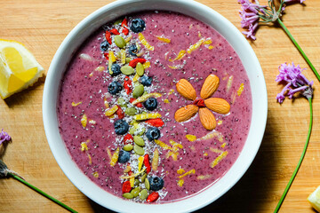 Strawberry and blueberry smoothie bowl topped with fresh blueberry, and chia seeds pudding, lemon zest and healthy summer fresh and refreshing breakfast drink/bowl 
