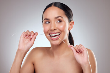 Dental floss, smile and thinking with teeth of woman in studio on gray background for cleaning and...