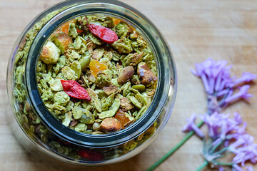 Green tea matcha granola made with raw oats, chia and flax seeds, almond and walnuts, dried apricot and goji berry, honey and coconut oil 
