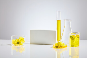 Minimalist style photo in white tones, some lab glassware and an empty podium, calendula flowers...
