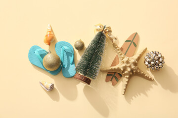 Composition with Christmas decorations, mini surf board and flip-flops on color background