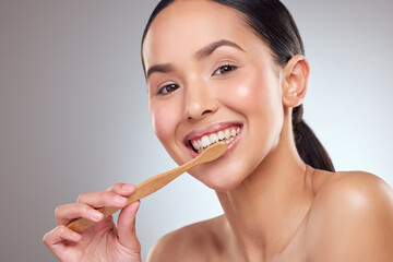 Portrait, smile and toothbrush with oral hygiene woman in studio on gray background for dental...