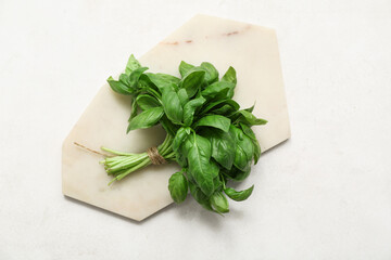 Board with fresh green basil leaves on white background