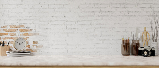 A white marble tabletop features painting tools and a space against the white brick wall.