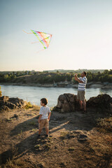dad and little son 3 years old fly a kite in a field. Involved Parenting, International Father's Day	