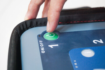 pressing the AED power button to turn it on and use a patient in cardiac arrest
