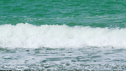 Sea Surface Near Shore. Waves Rolled On Sandy Shore. Turquoise Waves With Clear Water. Slow motion.