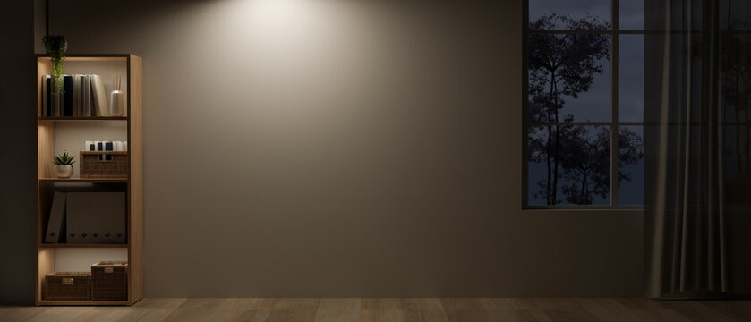 An empty room at night with a bookshelf, a dim light on an empty wall, and a rustic wooden floor.