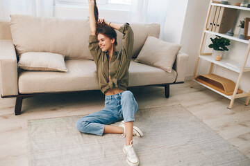 Happy woman enjoying a cosy moment on a modern sofa in her peaceful apartment.