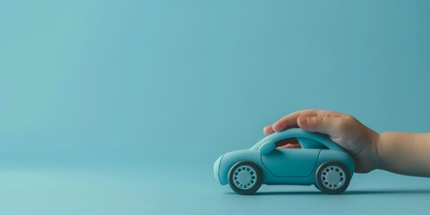 A blue toy car is being held by a small hand