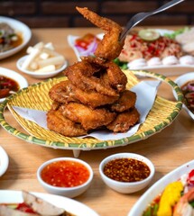 Air fryer chicken wings glazed with hot chilli sauce and served with different sauces. isolated on white background . top view
