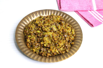 Akkha Masoor is an Indian dish cooked with whole red lentils, spices, onions, tomatoes, garlic, and ginger. Rich, flavorful, and nutritious. Enjoy with rice or bread. masoor usal. masur chi bhaji - obrazy, fototapety, plakaty