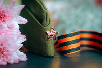 Soviet cap, St. George's ribbon on a background of flowers and glowing lights, symbols of the...