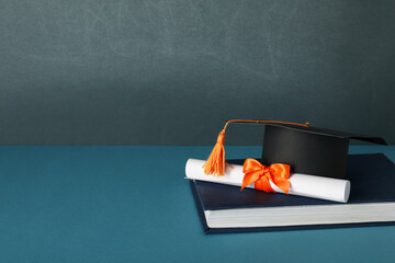 Graduate hat and books, on a blue background.