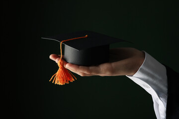 The hat of a university graduate, in his hands.