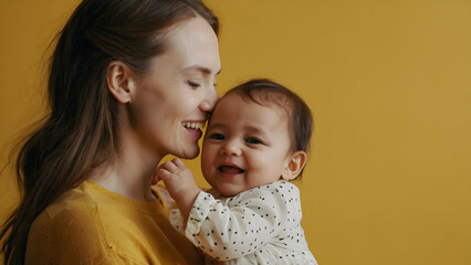 Portrait of happiness mother with baby on yellow background