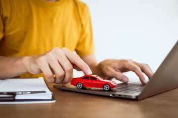 Close up man in yellow T-shirt working at desk. Automobile agreement and insurance documents. Legal investment strategy for auto protection. Crash liability, expense, risk management for success.