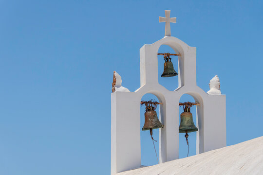 Santorini, Greece, May 3, 2024. Three bells of an Orthodox church with a blue sky - Powered by Adobe