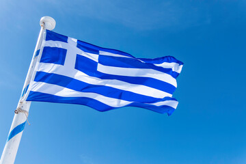 Santorini, Greece, May 3, 2024. Greek flag on the path between Fira and Oia