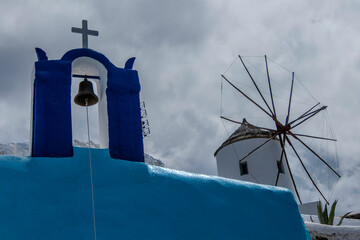Santorini, Greece, May 5, 2024. Oia, View of the village with the windmill, cross and bell