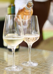 Person, glasses and bottle in winery for wine tasting, champagne and alcohol beverage with...