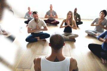 Diverse group of people in a yoga class doing a meditating pose