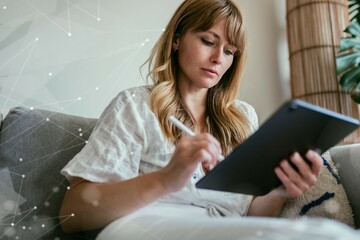 Woman using a stylus writing on a digital tablet during coronavirus quarantine