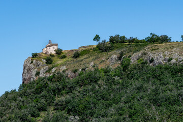 La chapelle Sainte Madeleine en haut de sa montagne dominant la vall&eacute;e de Massiac dans le Cantal entour&eacute;e de gros rochers par une belle journ&eacute;e d'&eacute;t&eacute;