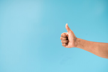 Thump up hand sign isolated on blue background.