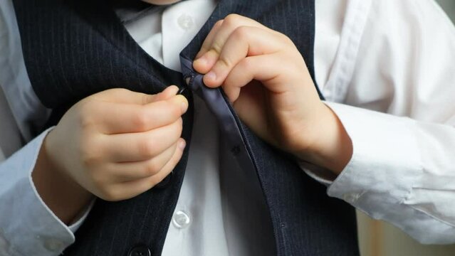 Little child learning to fasten and unbutton clothes, hands close-up