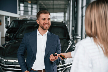 Businessman and woman are in a car dealership