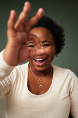Okay sign, eye and black woman portrait in studio with smile for approval, attitude or happy on...