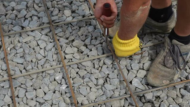 Knitting reinforcement manually. Preparation of reinforcement before pouring concrete. Construction site.