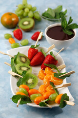 Fruit skewers with chocolate and mint.